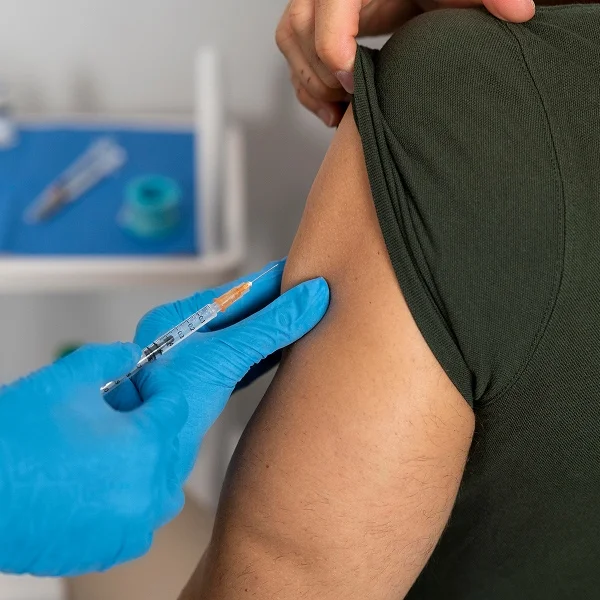 A person receives an injection from a doctor in a medical setting.